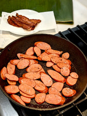 Bacon has been crisped, now frying sausage