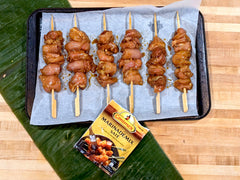 Chicken skewers lined up on baking sheet