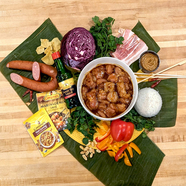 elaborate display of ingredients on a wooden counter lined with banana leaves