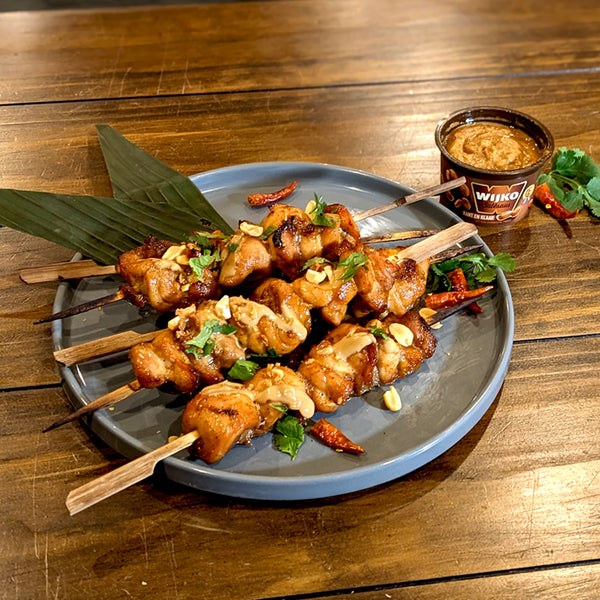 browned chicken satay skewers topped with peanut sauce and cilantro