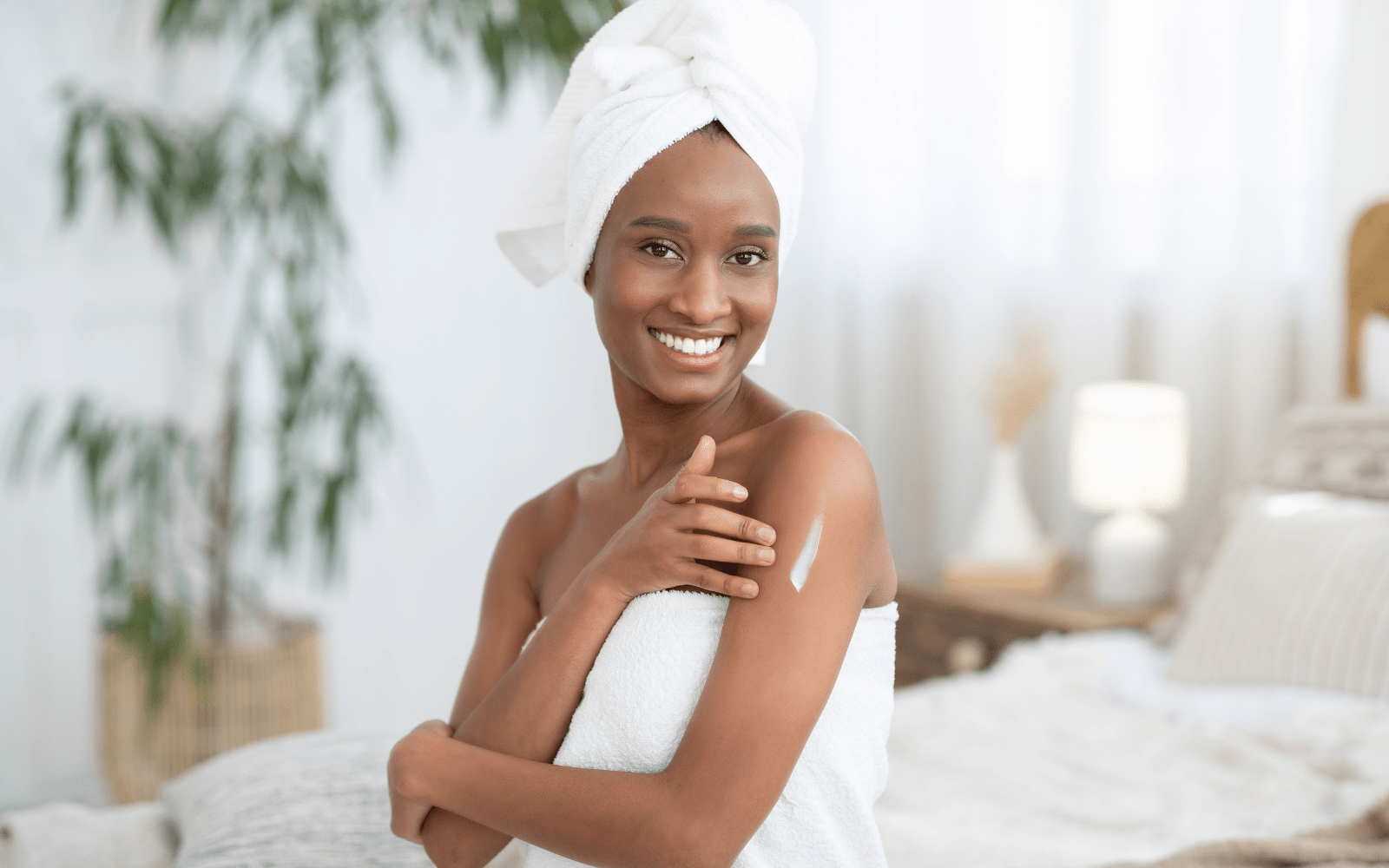 Mujer frotando crema hidratante holística en el brazo.