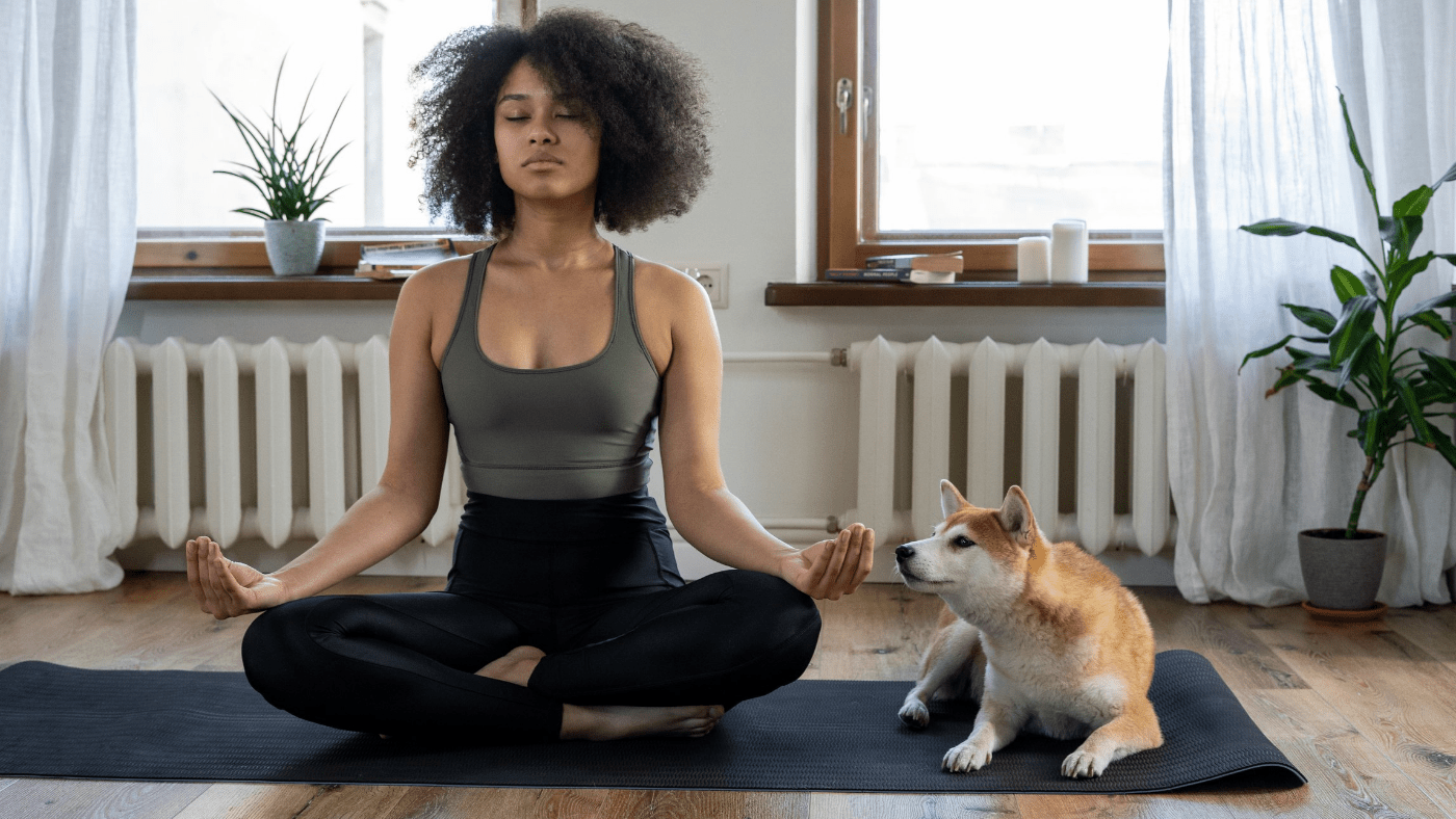 woman meditating with dog by her side