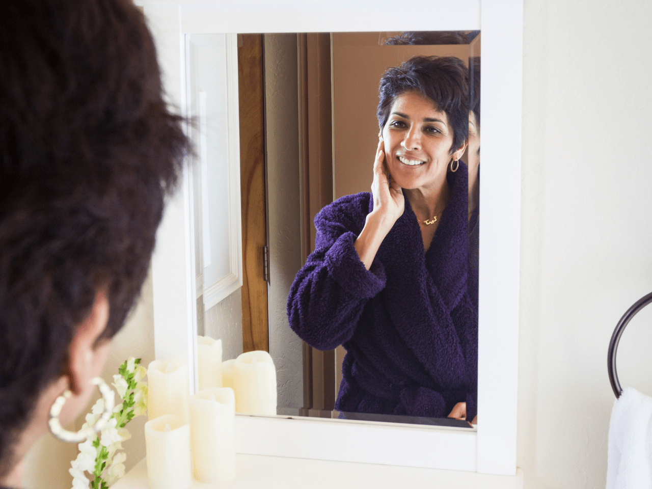 woman looking at herself in mirror practicing self love