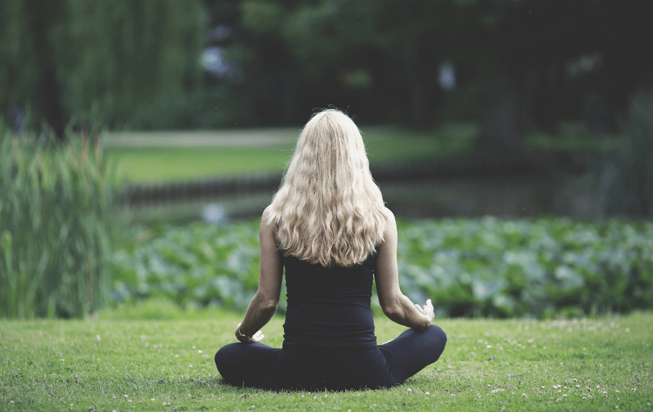 Mujer meditando para una piel más sana fuera del estudio Nefertem