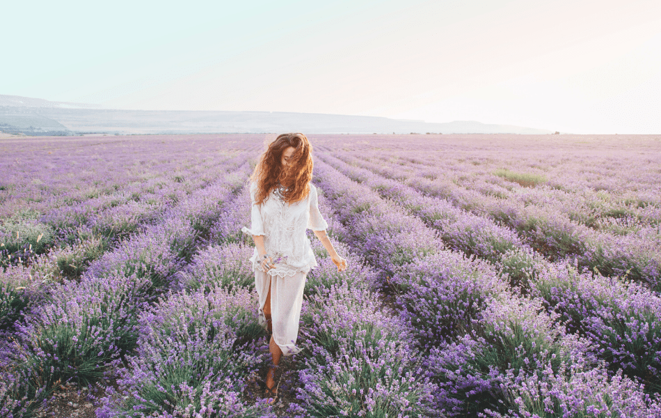 Mujer caminando por un campo de lavanda que puede reducir el estrés.