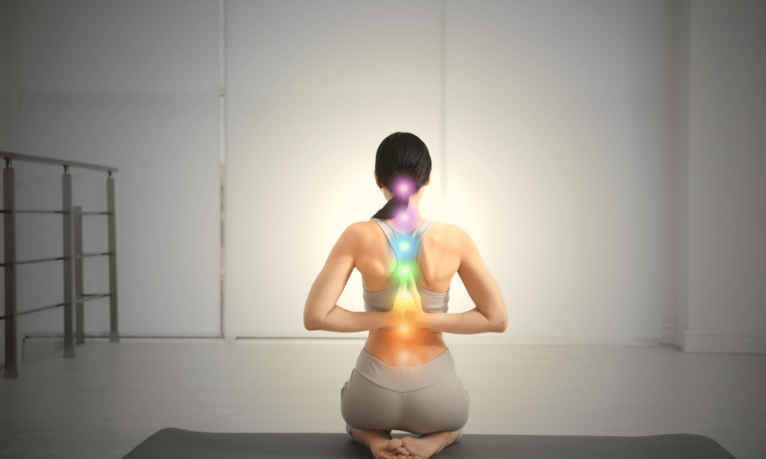 women doing yoga with 7 chakras visible on her spine