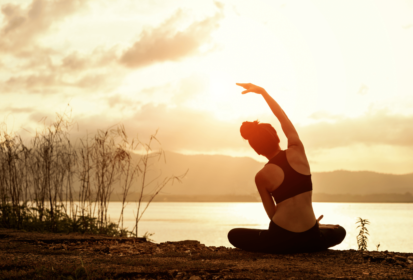 women doing yoga looking at sunset 