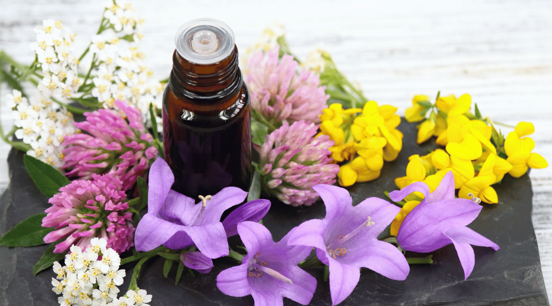 essential oil with flowers around it