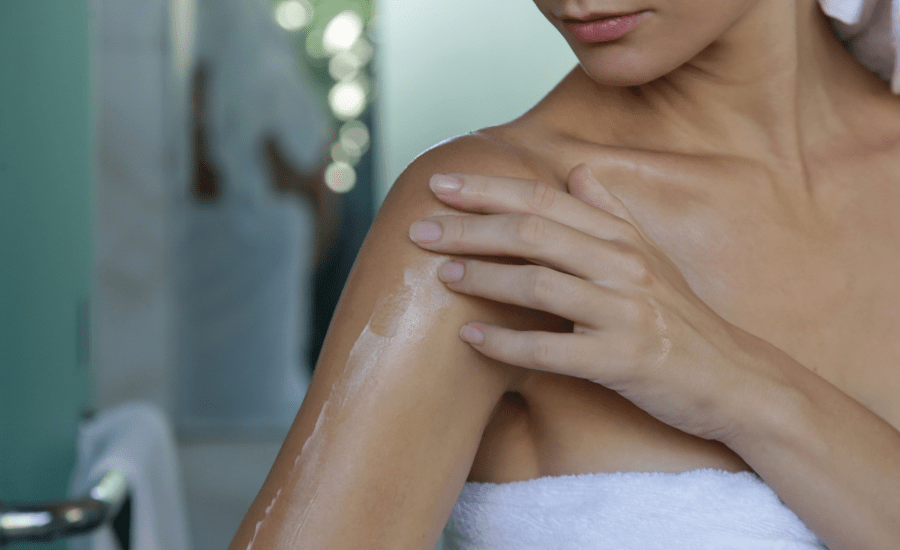 Women moisturizing arm with nefertem body butter 