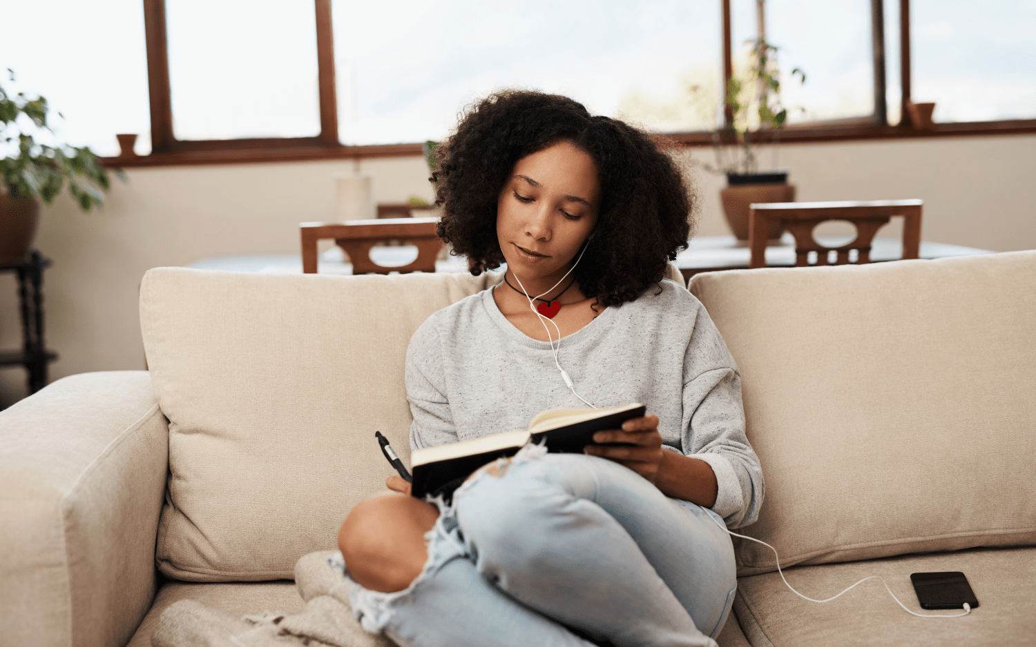 women journling on sofa 