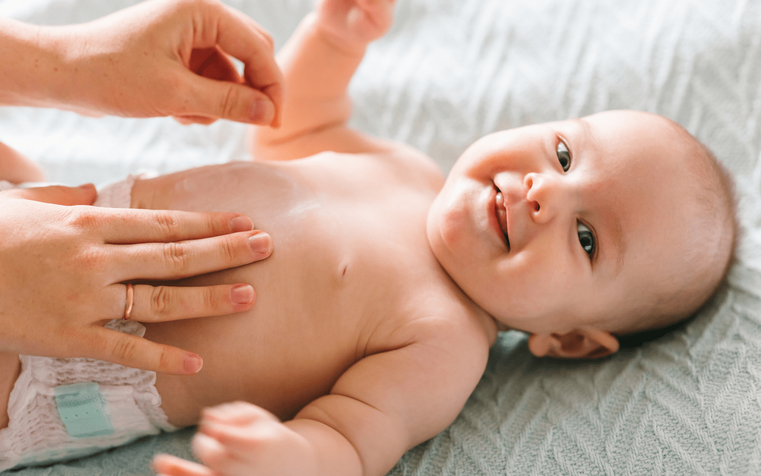 A baby being moisturized with Nefertem body butter 