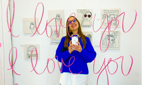 Kristin, taking a selfie in a mirror on which the words "i love you, i love you" are scrawled