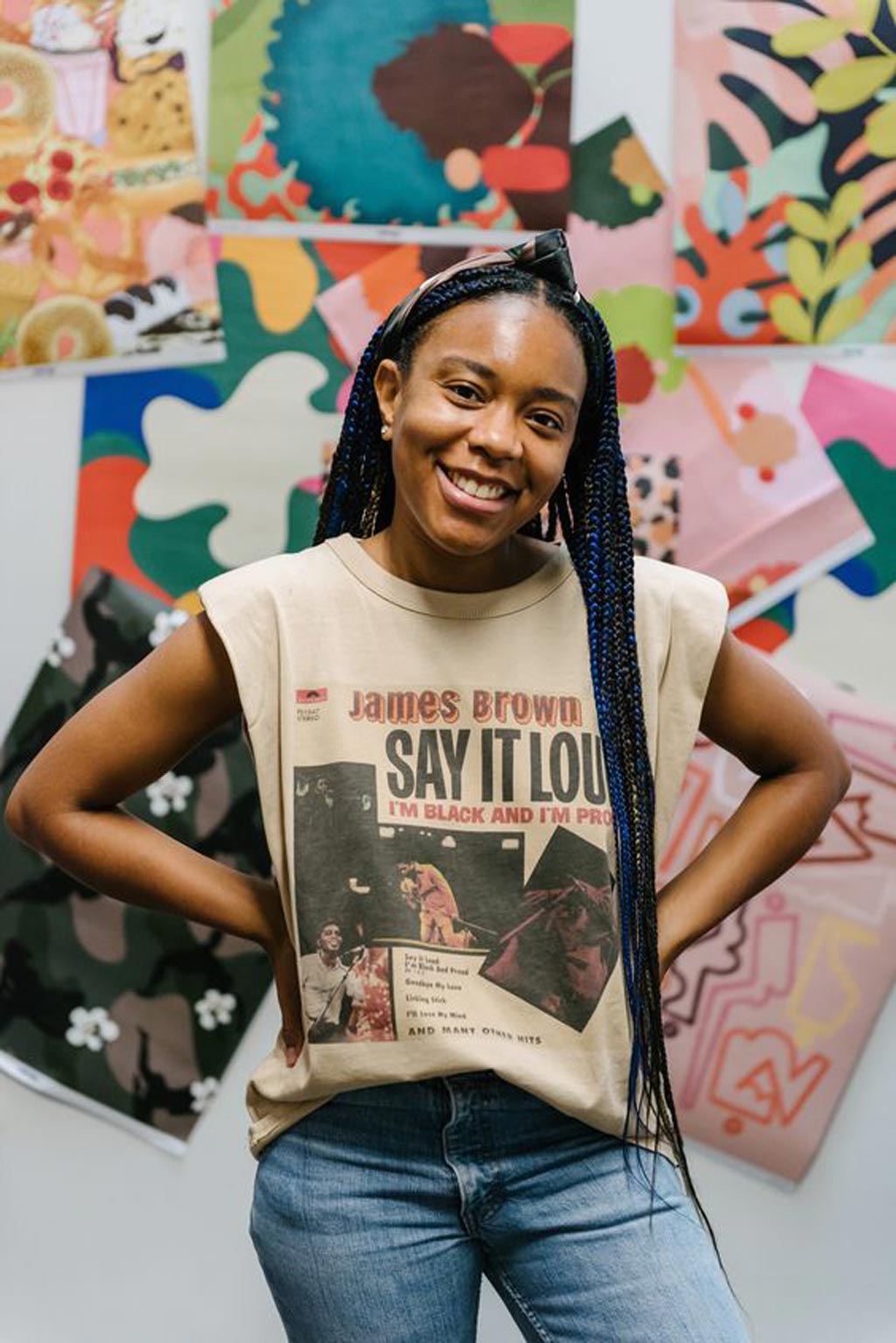 Ashley Fouyolle, standing in front of a wall with her wrapping papers and artworks pinned up