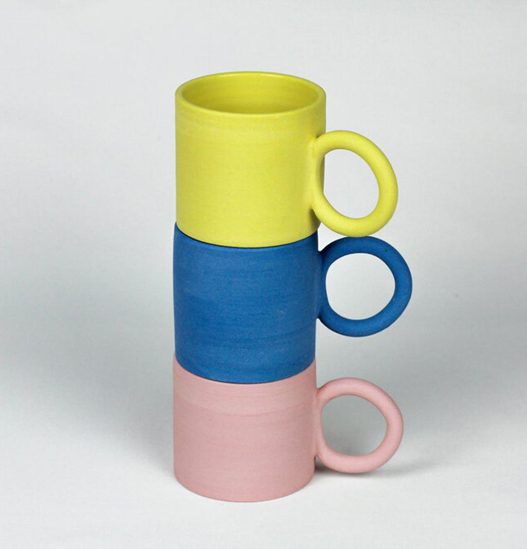 a stack of mugs in yellow, blue and pink