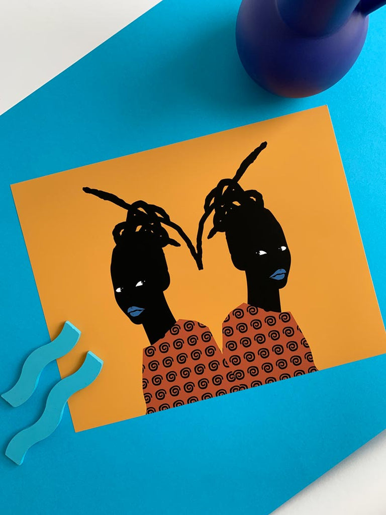 a print that depicts a black girl, symmetrically repeated, back to back. The colors are bold with gold in the background, the girl wearing an orange shirt, and her lips are bright blue