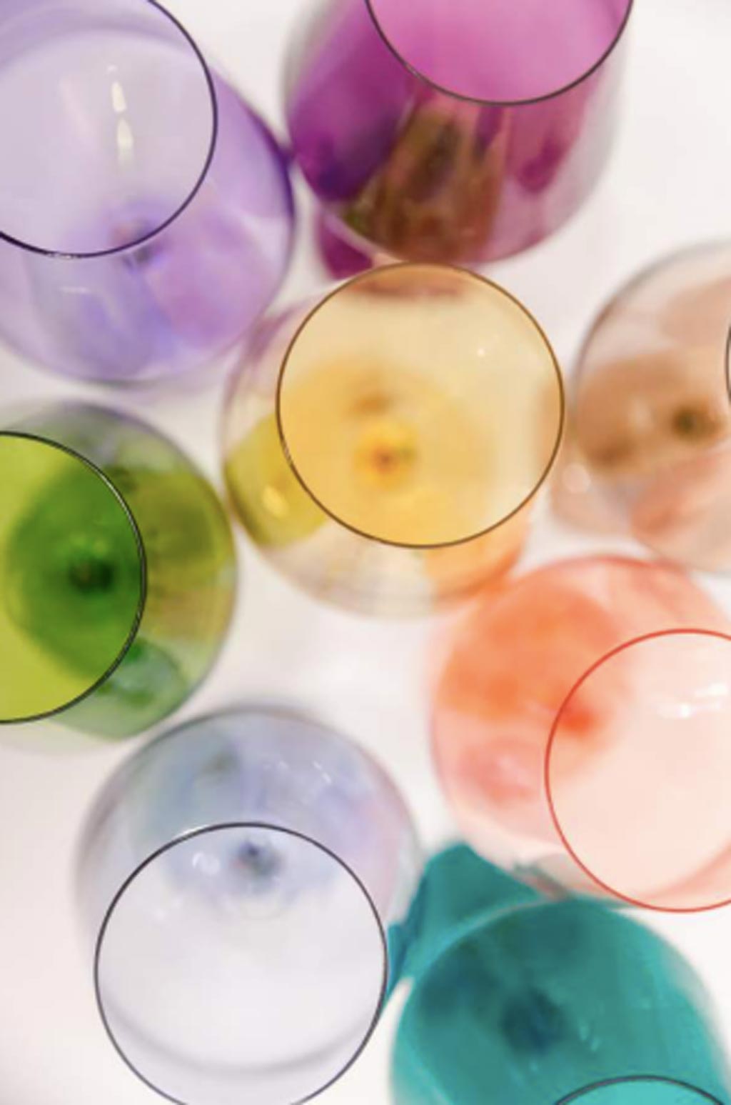 looking down onto various colors of colored-glass stemless wine glasses