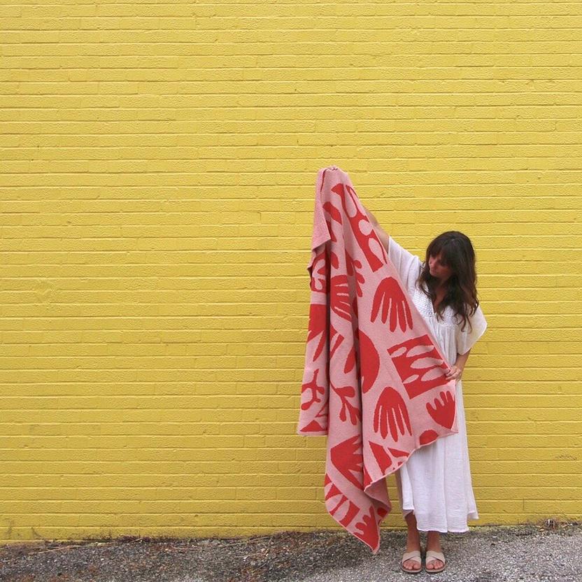 a pink and red blanket with an abstract pattern