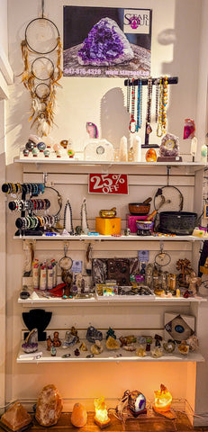 Display of crystals, jewelry and home decor items on white shelves