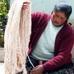 Peruvian woman weaving alpaca yarn - San Rocco Italia