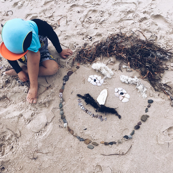 Child creating a beach collage face