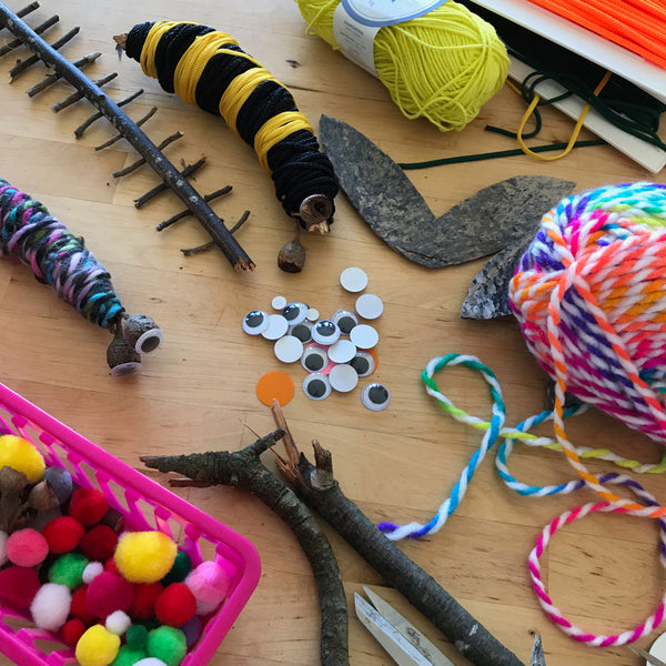 sticks, yarn and pom poms to make yarn wrapped bugs kids craft activity