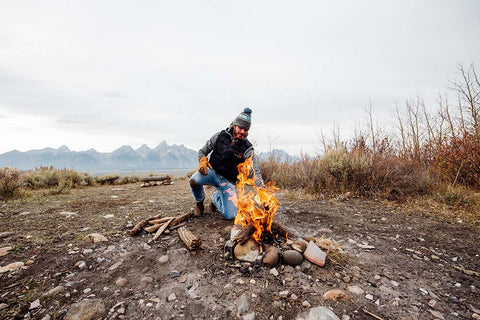 Bubba placing logs onto the fire