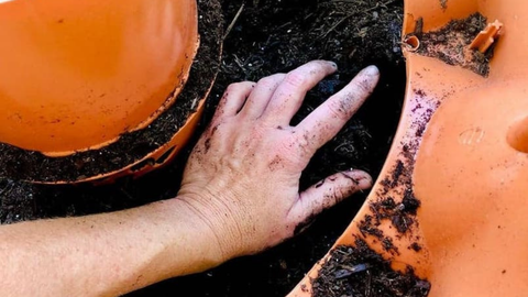 person filling Garden Tower® with soil