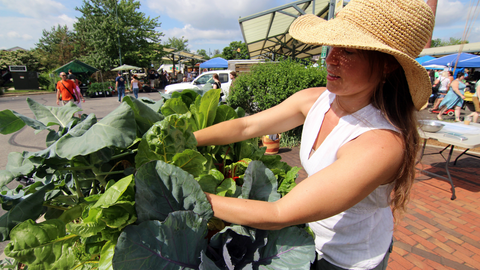 woman tending to vegetables in vertical vegetable garden