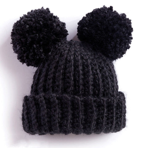 photo of black knit hat with pom poms