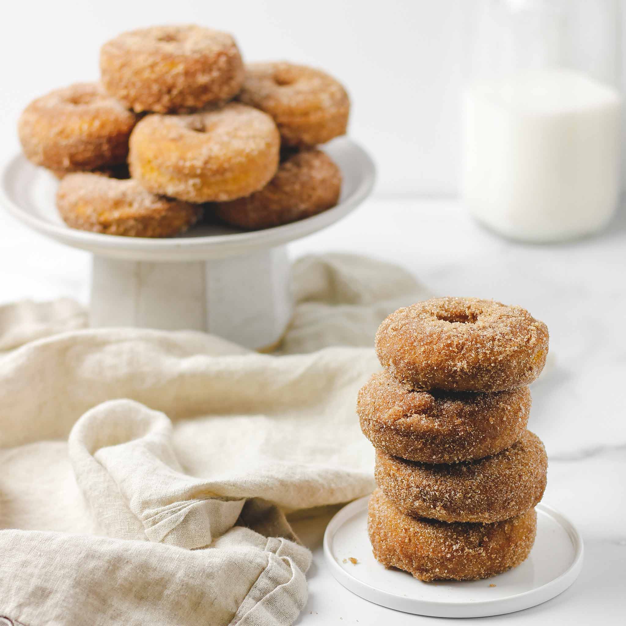 Pumpkin Spice Cinnamon Donuts in a pile on a serving plate