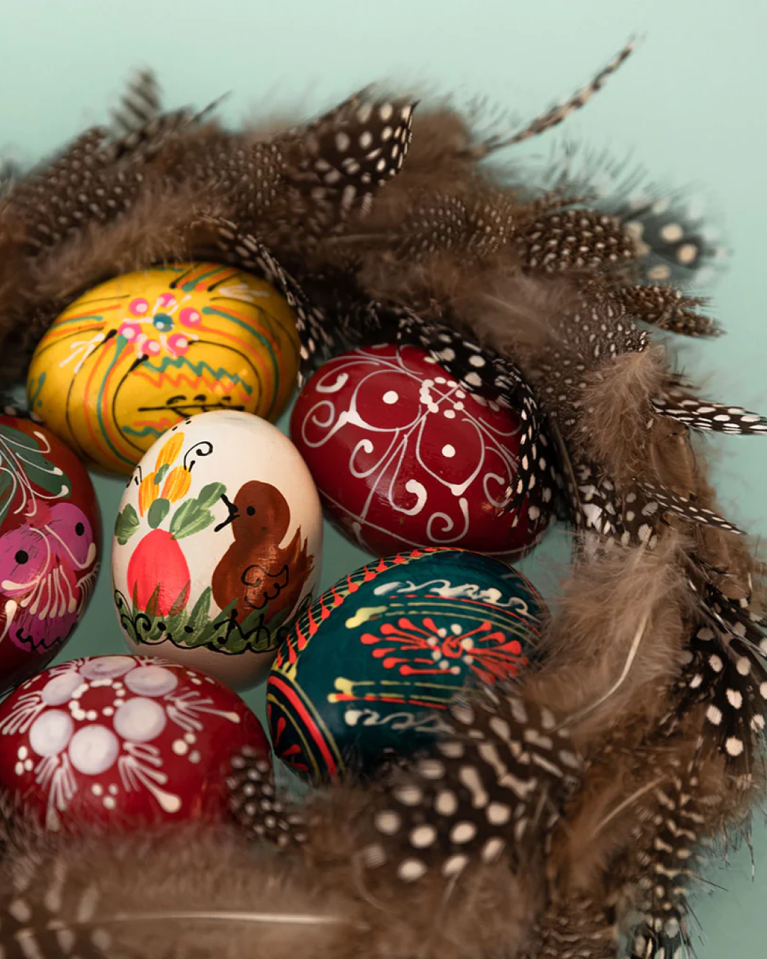 Assorted decorated eggs with bird feathers