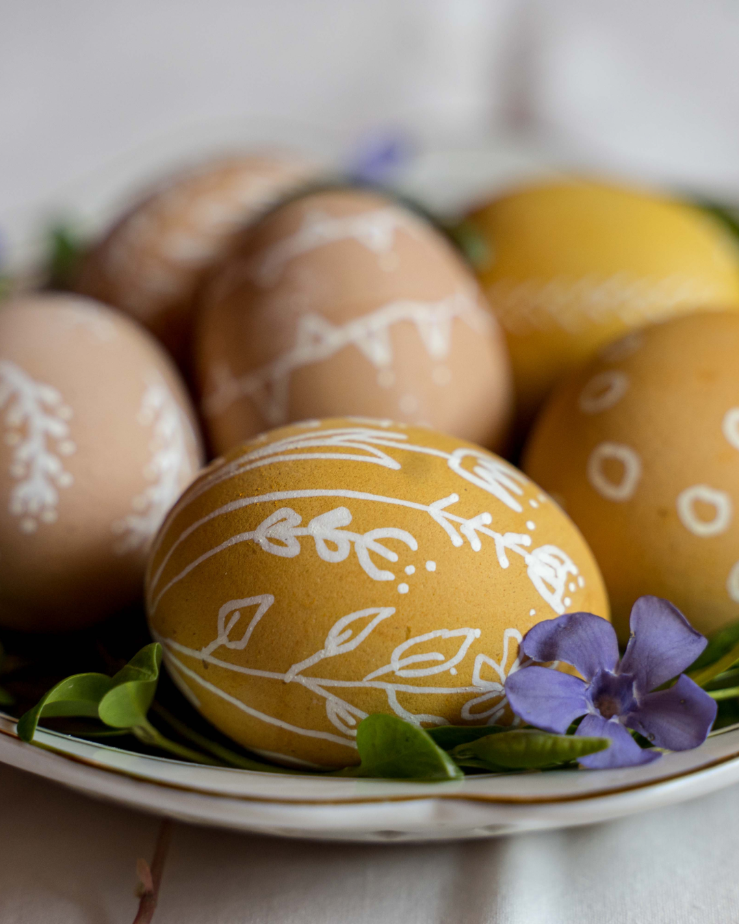 Yellow dip dyed easter eggs with wax design of flowers