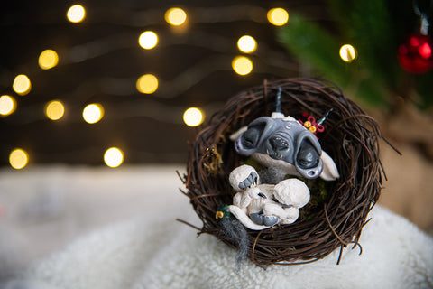 Mishes Official | White and gray sleeping baby krampus sculpture in nest.
