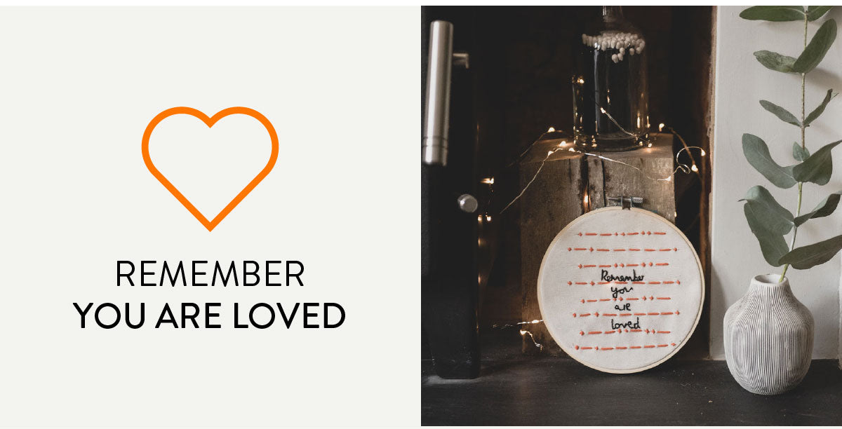 Remember you are loved. A hand embroidered hoop with the message 'remember you are loved' in english in black. The same message appears in morse code in orange threads. 