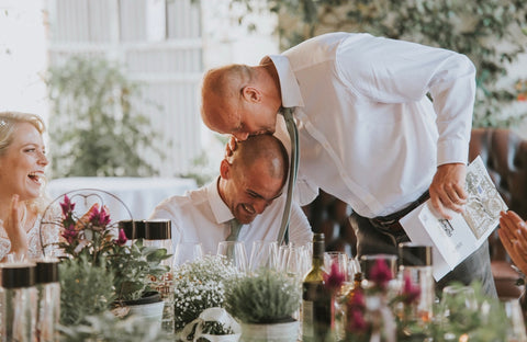 The groom, adorned in a sage green tie, delivering a heartfelt wedding speech with sincerity and emotion, captivating the audience with his words of love and commitment on this special day.