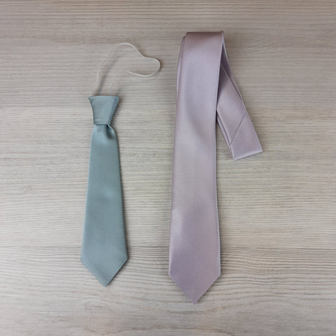 Image featuring a collection of boys' ties, including an elasticated tie and a self-tie tie, displayed against a neutral background. The elasticated tie is neatly pre-tied, while the self-tie tie showcases intricate knot details, offering options for various preferences and occasions.