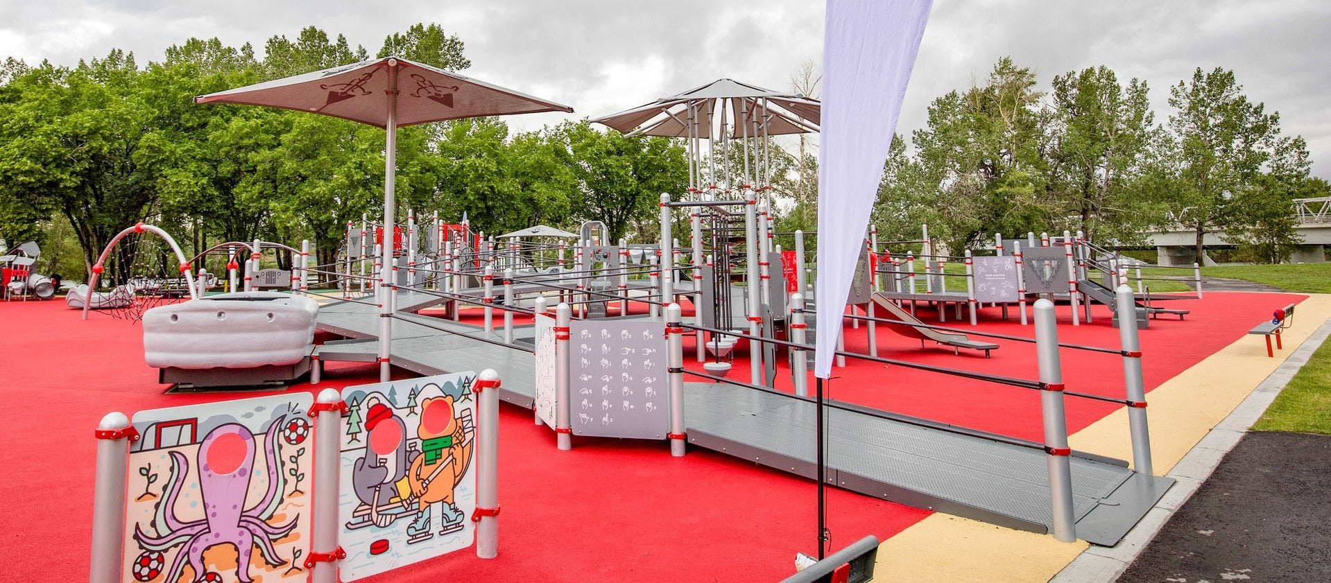 A photo of the Jumpstart Inclusive Playground in Calgary, AB showing the double-wide ramps and seamless surfacing.