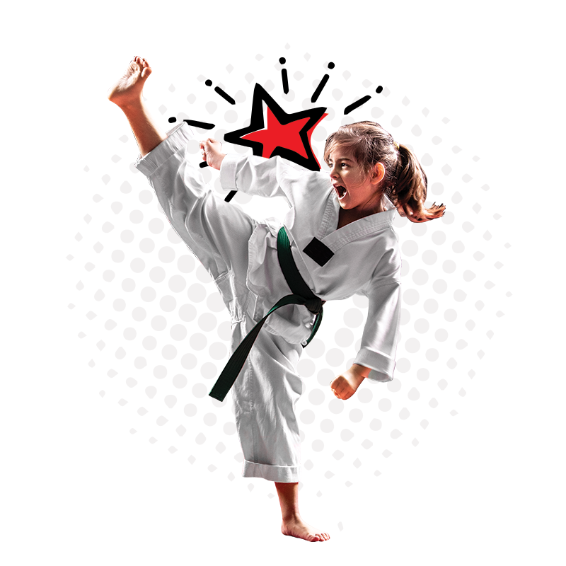 A girl in a karate uniform kicks her foot into the air.