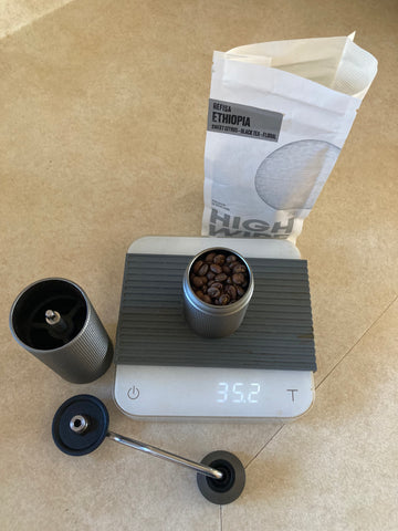 Timemore Chestnut C2 Max Grinder on a scale with coffee beans