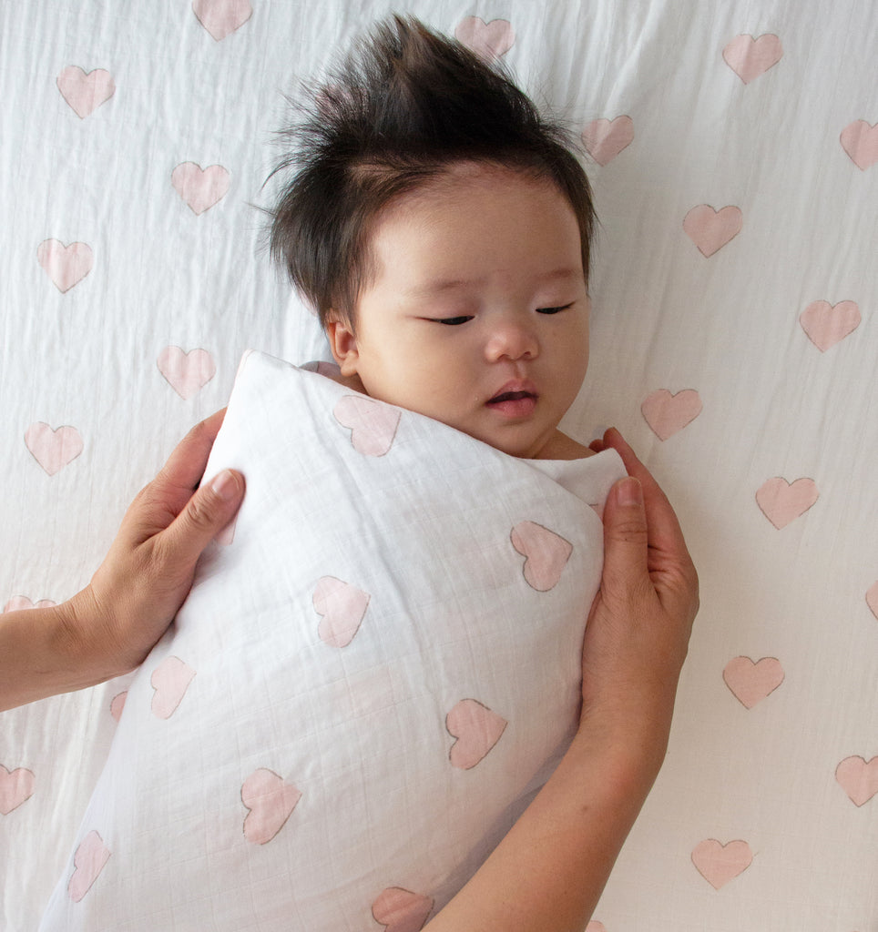 Baby swaddled in pink hearts percale muslin wrap