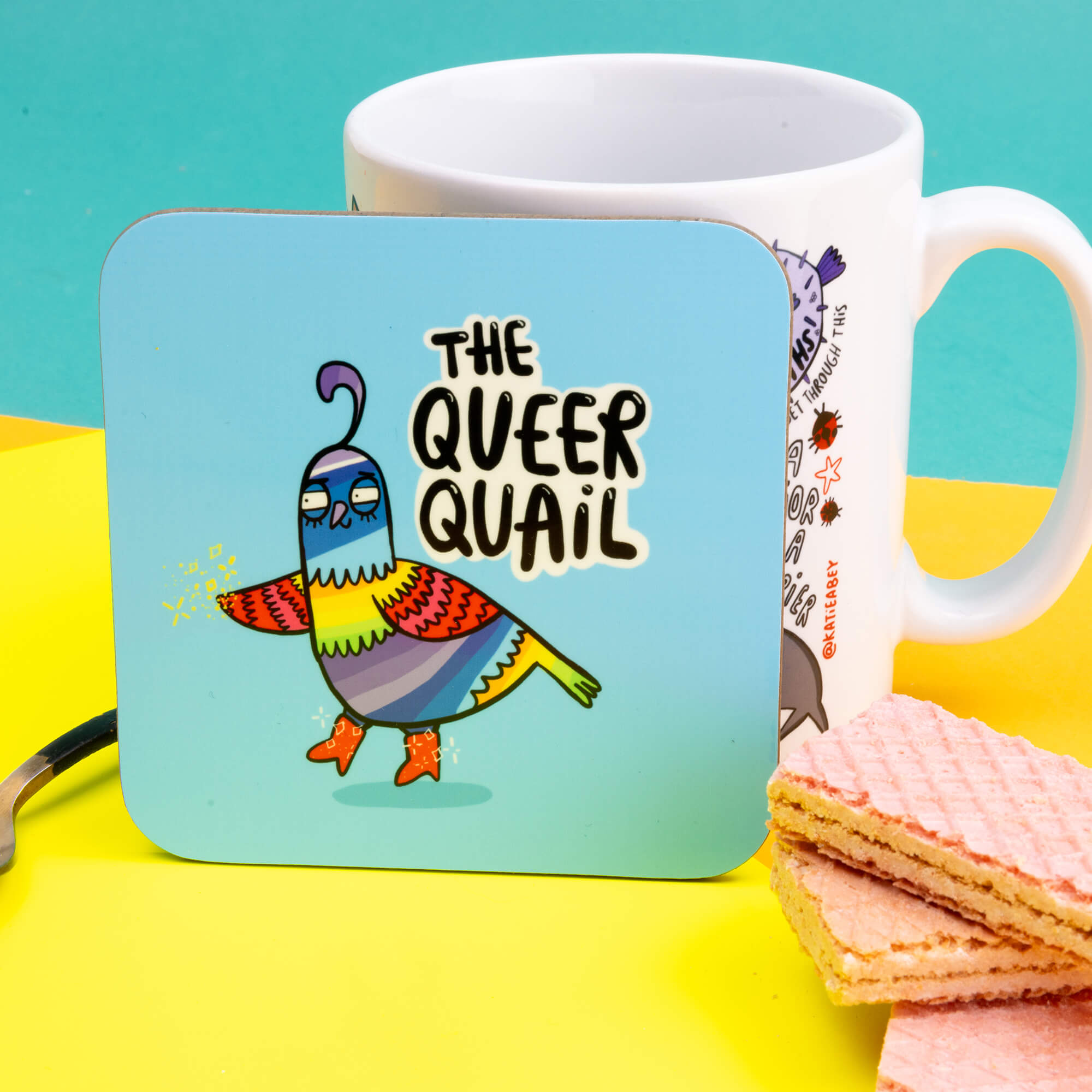 Queer Quail Coaster is a rainbow illustration of a quail with red boots on looking fabulous illustrated by Katie Abey next to it text reads 'the Queer Quail