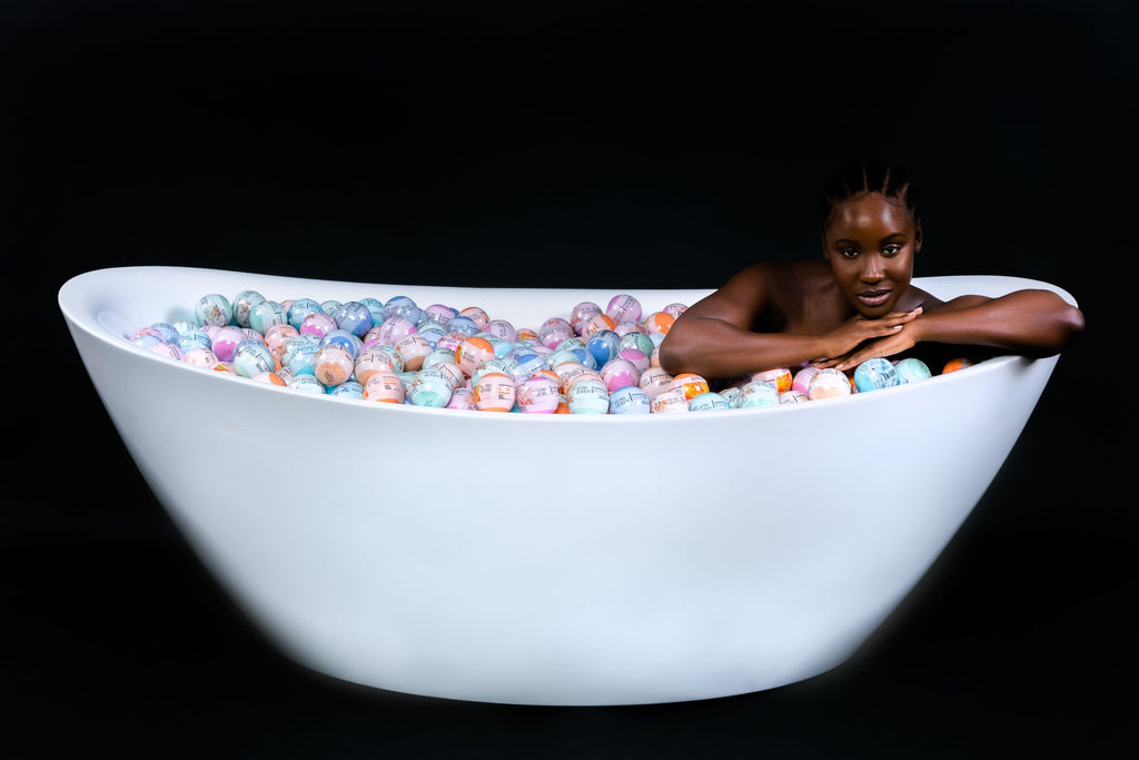 Model sits in a bathtub filled of Kush Queen bath bombs