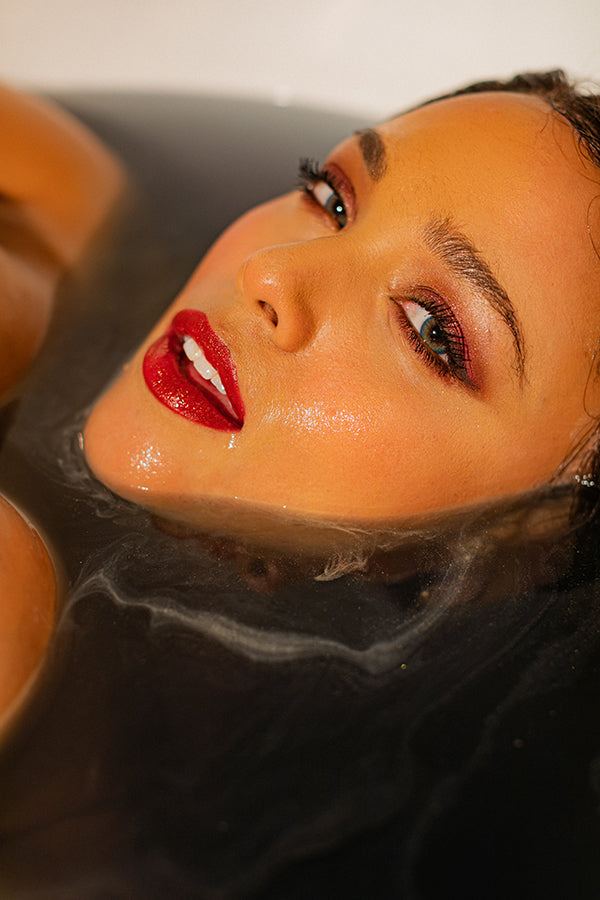 Model fully submerged in Black Magic CBD Bath with only their face showing out of the water.