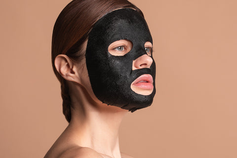 woman wearing charcoal sheet mask 