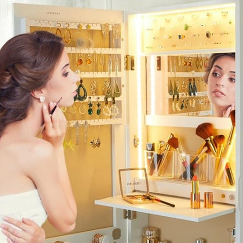 A woman putting her makeup in front of LUXFURNI Jewelry Cabinet