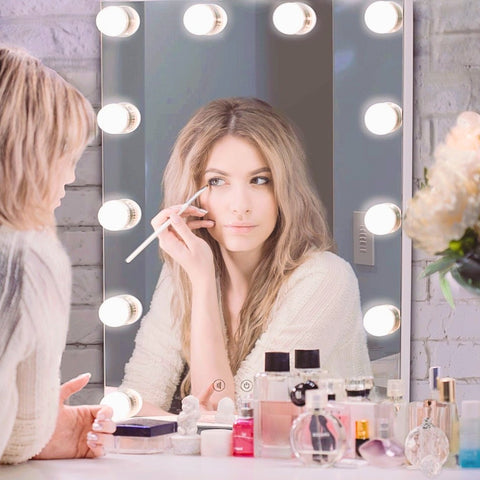 A woman applying her eyeshadow in front of a Makeup Mirror