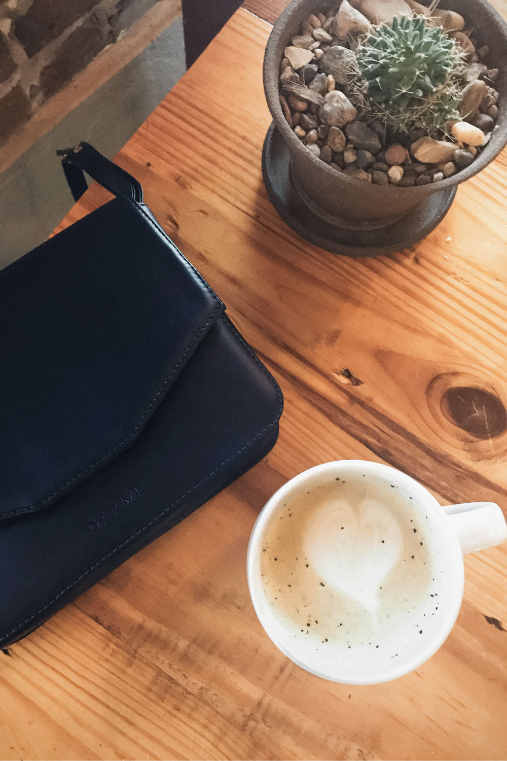 chic ethique drinking coffee with daame tate crossbody