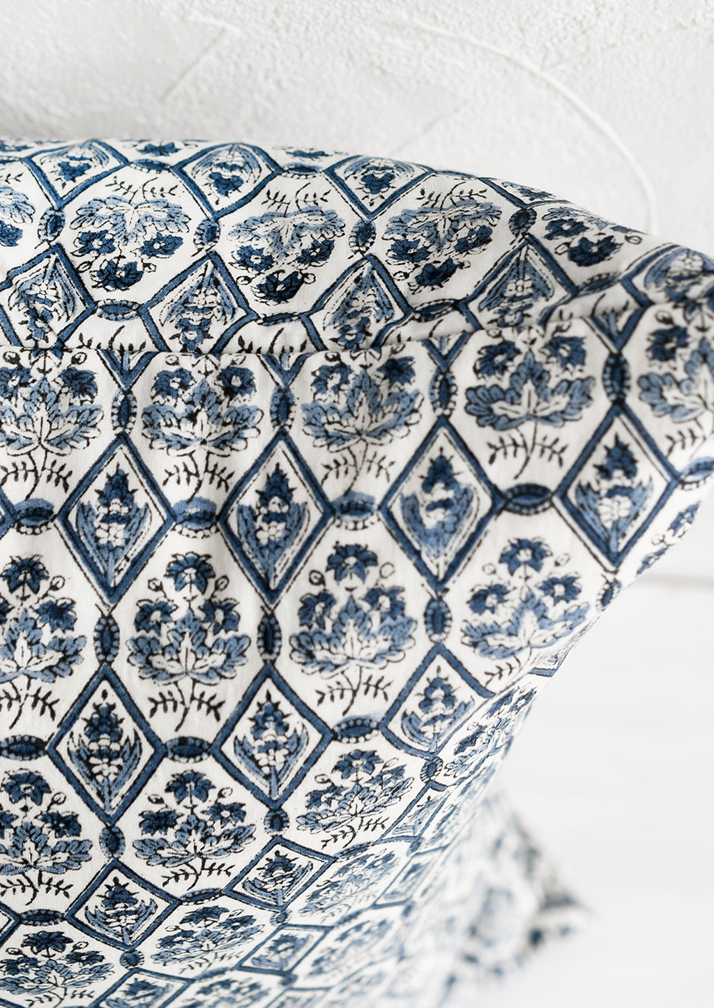 3: A block printed pillow in blue and white tile print.