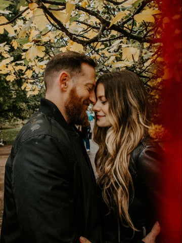 Man with beard cuddling long-hair woman in park