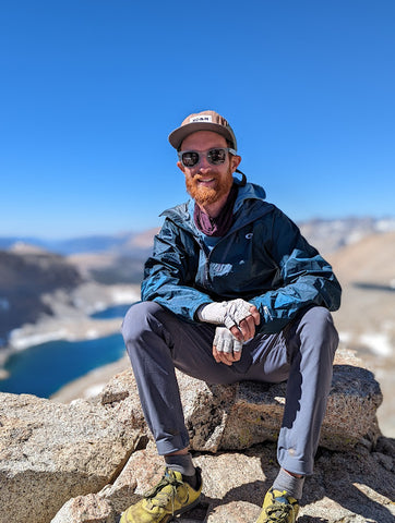 Josh Sheets sitting at an alpine peak